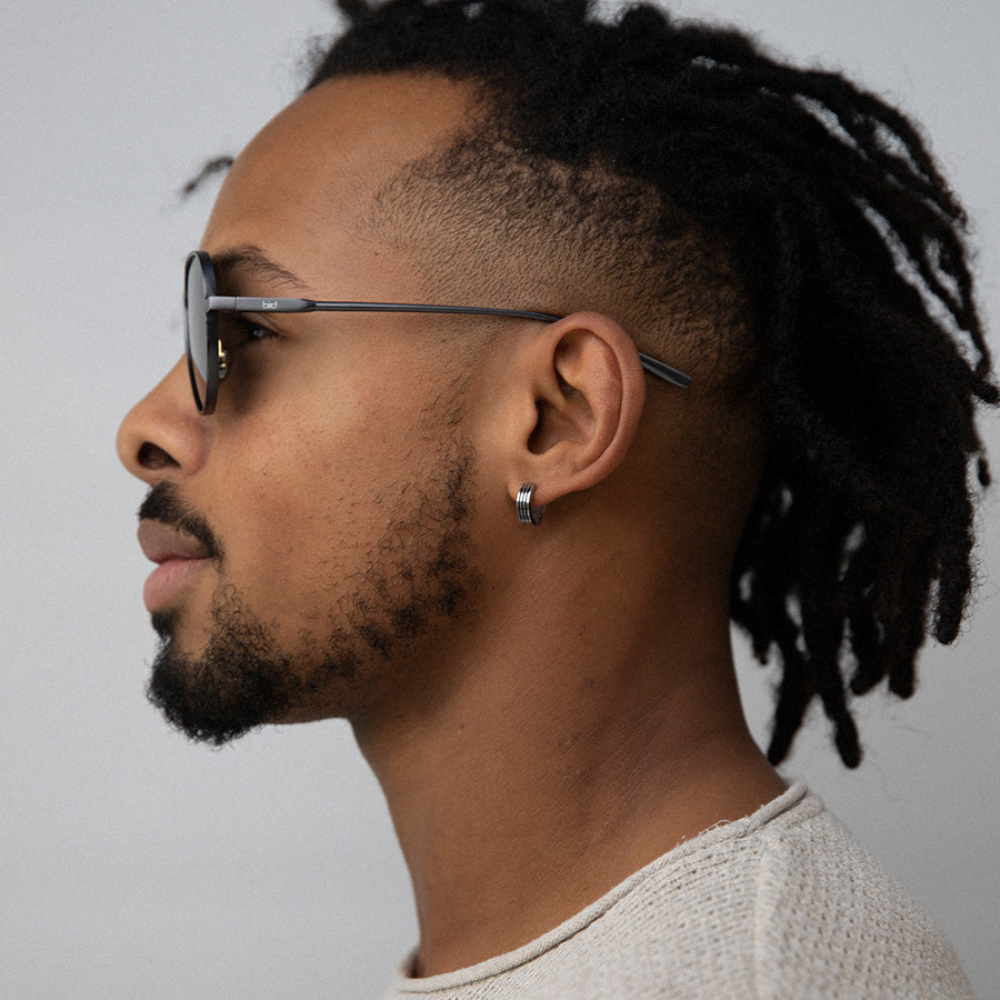 Black Man wearing aviator sunglasses with polarised lenses facing sideways