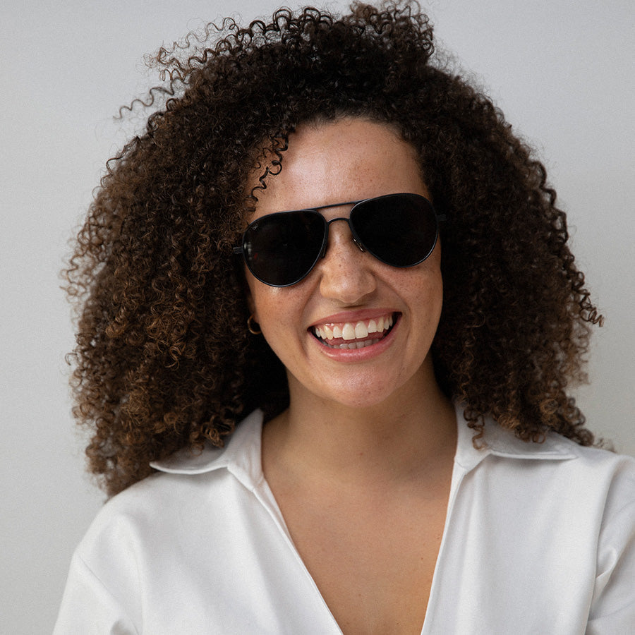 Black woman wearing aviator sunglasses with polarised lenses