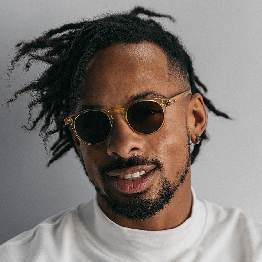 Black man wearing round yellow frame sunglasses